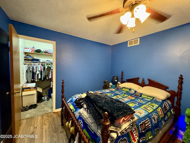 128 Don Dr, Linn, MO 65051 - bedroom featuring wood finished floors, a closet, a textured ceiling, and a ceiling fan