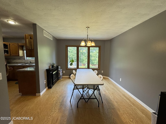 128 Don Dr, Linn, MO 65051 - dining room with light wood-style flooring, a textured ceiling, and a chandelier