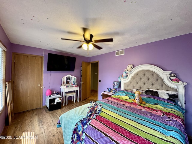 128 Don Dr, Linn, MO 65051 - bedroom featuring wood finished floors, ceiling fan, a textured ceiling, and a closet