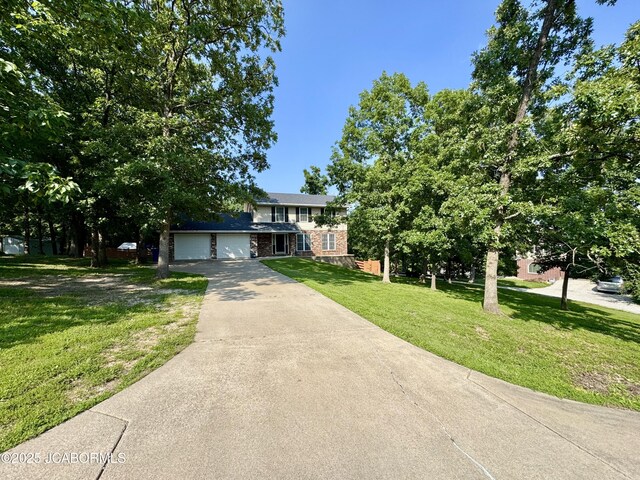 128 Don Dr, Linn, MO 65051 - traditional-style home featuring a garage, brick siding, concrete driveway, and a front lawn