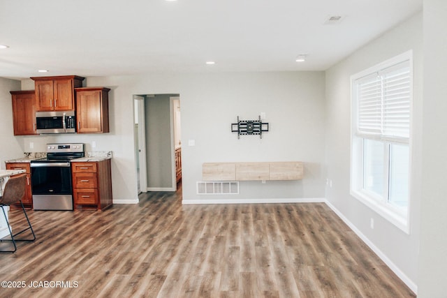 138 Stonegate Ave, Linn, MO 65051 - kitchen with stainless steel appliances, recessed lighting, brown cabinetry, wood finished floors, and baseboards