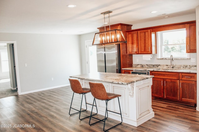 138 Stonegate Ave, Linn, MO 65051 - kitchen with freestanding refrigerator, a breakfast bar area, a sink, a center island, and light stone counters