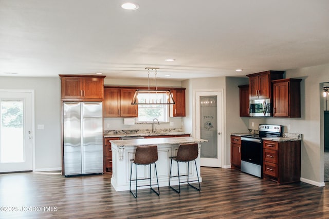 138 Stonegate Ave, Linn, MO 65051 - kitchen with appliances with stainless steel finishes, dark wood-style floors, a kitchen bar, a center island, and recessed lighting