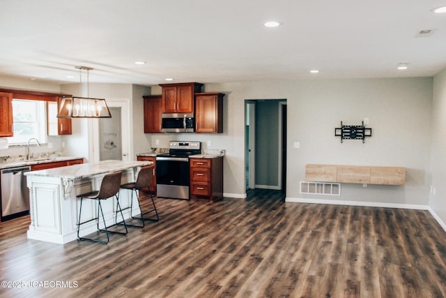 138 Stonegate Ave, Linn, MO 65051 - kitchen featuring stainless steel appliances, recessed lighting, a kitchen breakfast bar, dark wood-type flooring, and a center island