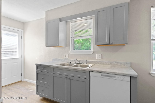 1906 Swifts Hwy, Jefferson City, MO 65109 - kitchen with dishwasher, gray cabinetry, a sink, light wood-type flooring, and light countertops