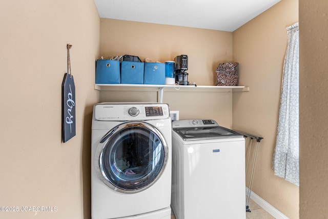 washroom featuring washer and dryer, laundry area, and baseboards