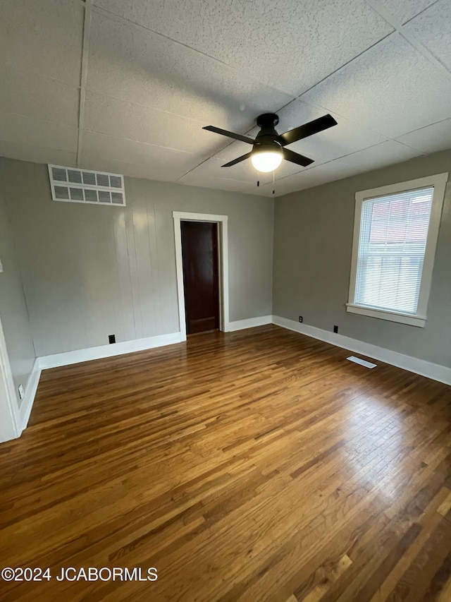 unfurnished room with hardwood / wood-style flooring, ceiling fan, and a paneled ceiling