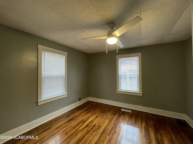 spare room with wood-type flooring, a paneled ceiling, and ceiling fan