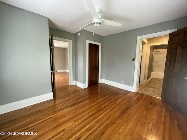 unfurnished bedroom featuring ceiling fan and dark hardwood / wood-style floors