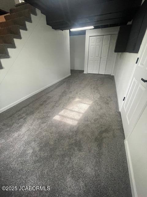 finished below grade area featuring stairway, carpet floors, and baseboards
