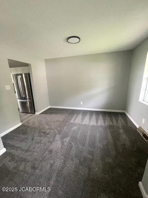 carpeted empty room with baseboards and visible vents