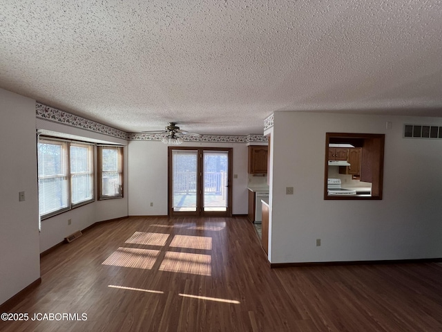 2362 County Road 4032, Holts Summit, MO 65043 - spare room featuring ceiling fan, plenty of natural light, dark wood-type flooring, and a textured ceiling