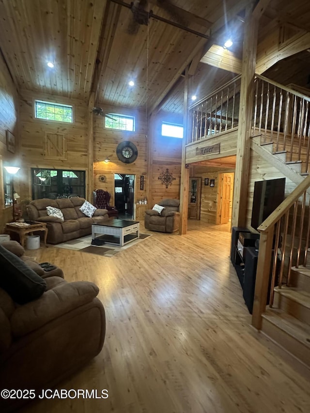 11 Copperhead Rd, Eldon, MO 65026 - living area featuring high vaulted ceiling, wood walls, wood-type flooring, stairs, and plenty of natural light