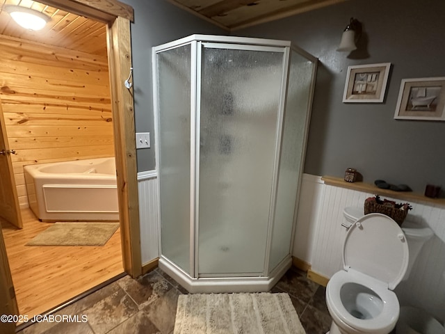 11 Copperhead Rd, Eldon, MO 65026 - bathroom featuring a stall shower, wooden walls, a bath, and a wainscoted wall
