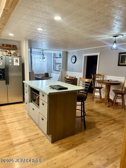 11 Copperhead Rd, Eldon, MO 65026 - kitchen featuring stainless steel appliances, a kitchen island, a breakfast bar area, light wood-style floors, and recessed lighting