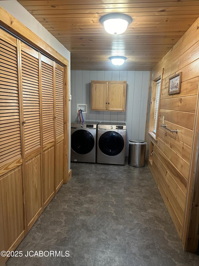 11 Copperhead Rd, Eldon, MO 65026 - washroom with cabinet space, washer and dryer, wood walls, wood ceiling, and dark flooring
