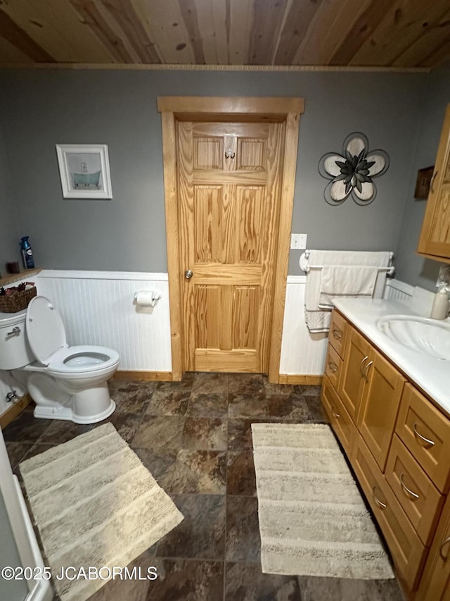 11 Copperhead Rd, Eldon, MO 65026 - bathroom featuring vanity, wood ceiling, wainscoting, and stone finish flooring