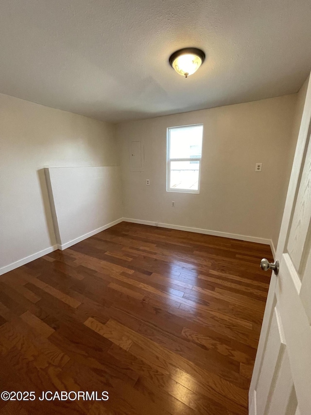 106 S Main St, Chamois, MO 65024 - spare room featuring dark wood finished floors, baseboards, and a textured ceiling