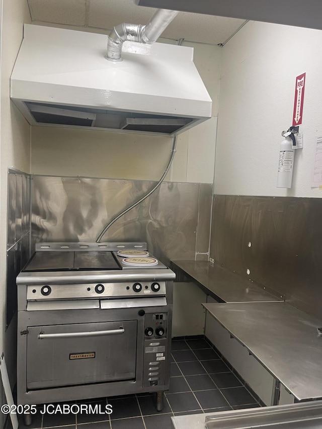 106 S Main St, Chamois, MO 65024 - kitchen featuring ventilation hood, dark tile patterned flooring, and range
