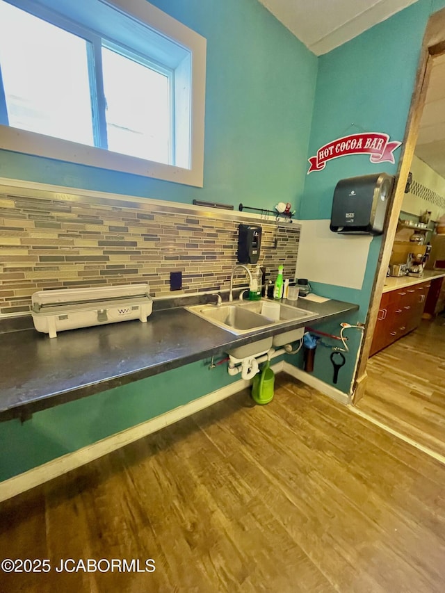 106 S Main St, Chamois, MO 65024 - kitchen with a sink, decorative backsplash, and wood finished floors