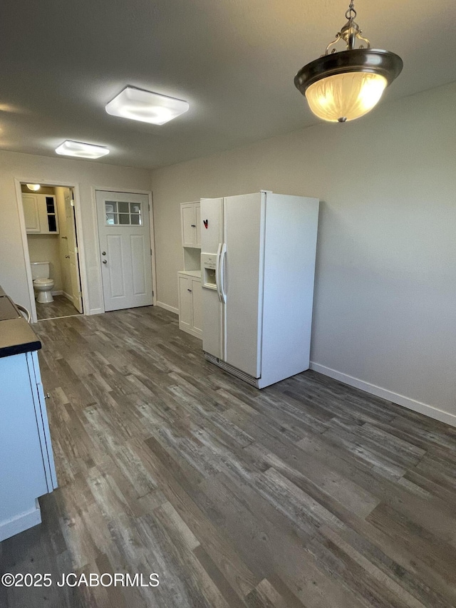 106 S Main St, Chamois, MO 65024 - kitchen with white fridge with ice dispenser, dark wood-type flooring, baseboards, and white cabinets