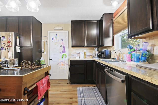 kitchen featuring light wood-type flooring, dark brown cabinets, a textured ceiling, stainless steel appliances, and sink