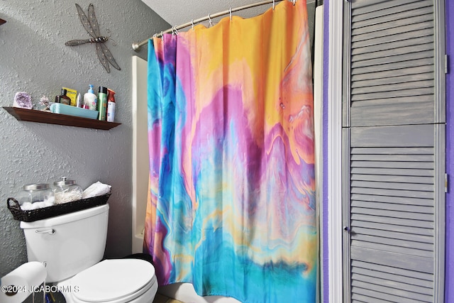 bathroom featuring toilet, shower / bath combo with shower curtain, and a textured ceiling