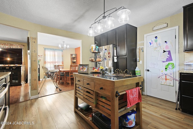 kitchen with pendant lighting, light hardwood / wood-style floors, and a textured ceiling