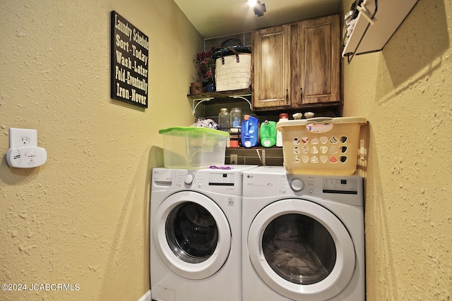 clothes washing area featuring cabinets and independent washer and dryer