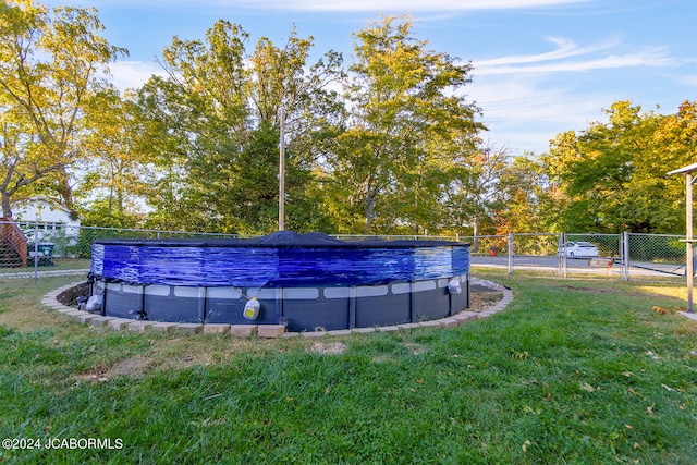 view of swimming pool featuring a yard