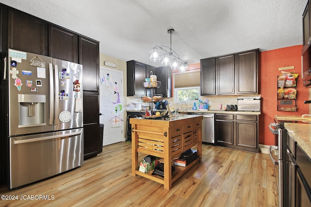 kitchen featuring light hardwood / wood-style floors, pendant lighting, a textured ceiling, dark brown cabinets, and appliances with stainless steel finishes