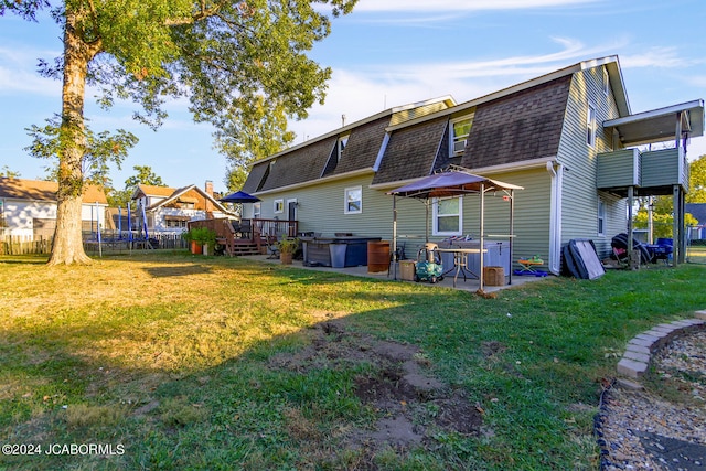 back of house featuring a yard and a wooden deck