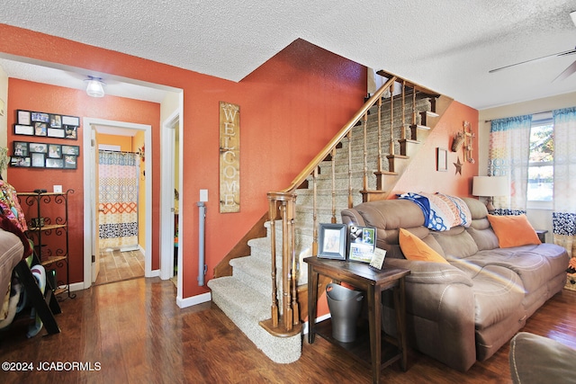 living room with a textured ceiling, dark hardwood / wood-style flooring, and ceiling fan