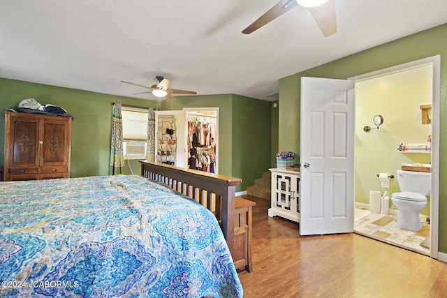 bedroom with ceiling fan, a spacious closet, connected bathroom, wood-type flooring, and a closet