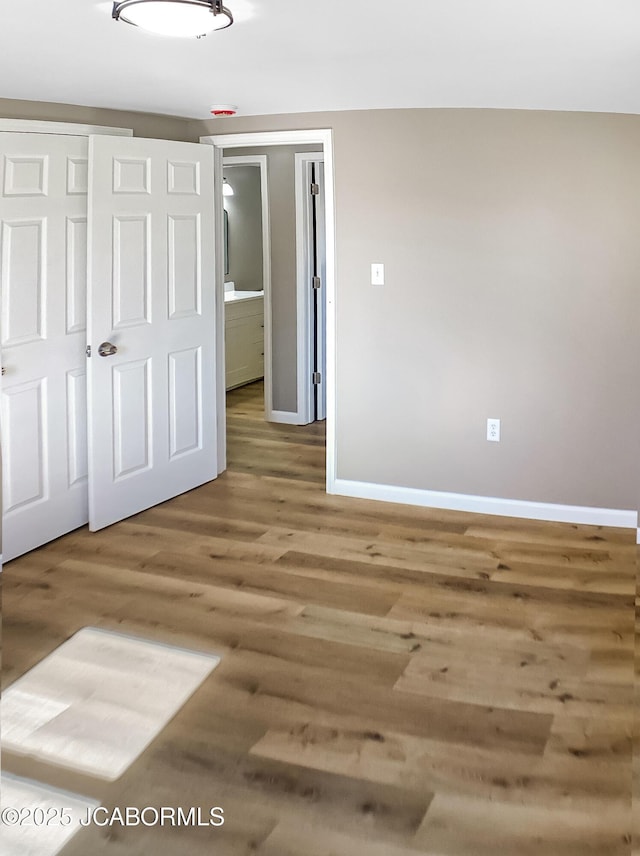 empty room featuring baseboards and wood finished floors