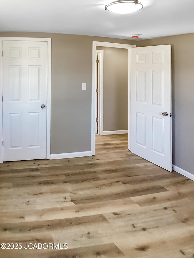 empty room featuring baseboards and wood finished floors