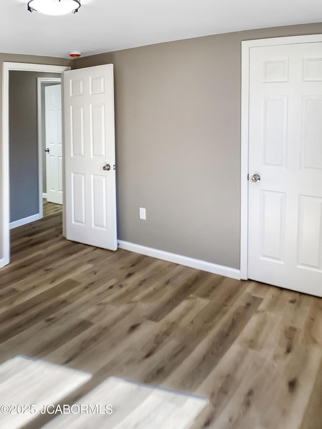 unfurnished bedroom featuring baseboards and wood finished floors