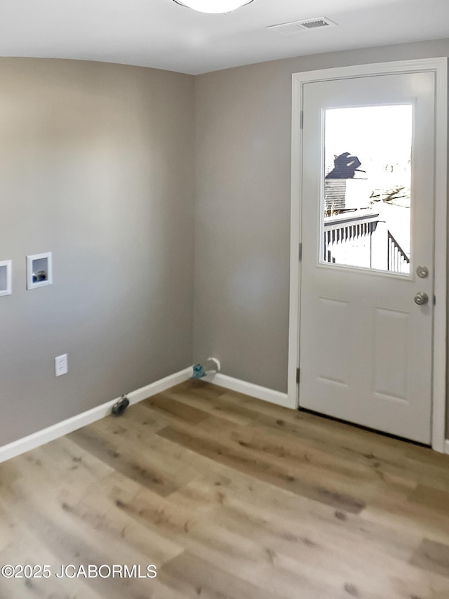 clothes washing area with hookup for a washing machine, laundry area, visible vents, baseboards, and light wood finished floors