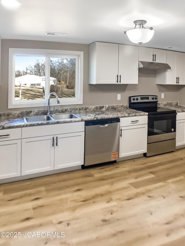 kitchen featuring visible vents, white cabinets, stainless steel appliances, under cabinet range hood, and a sink