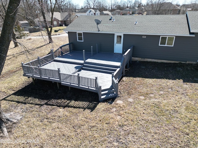 back of property featuring a shingled roof and a wooden deck