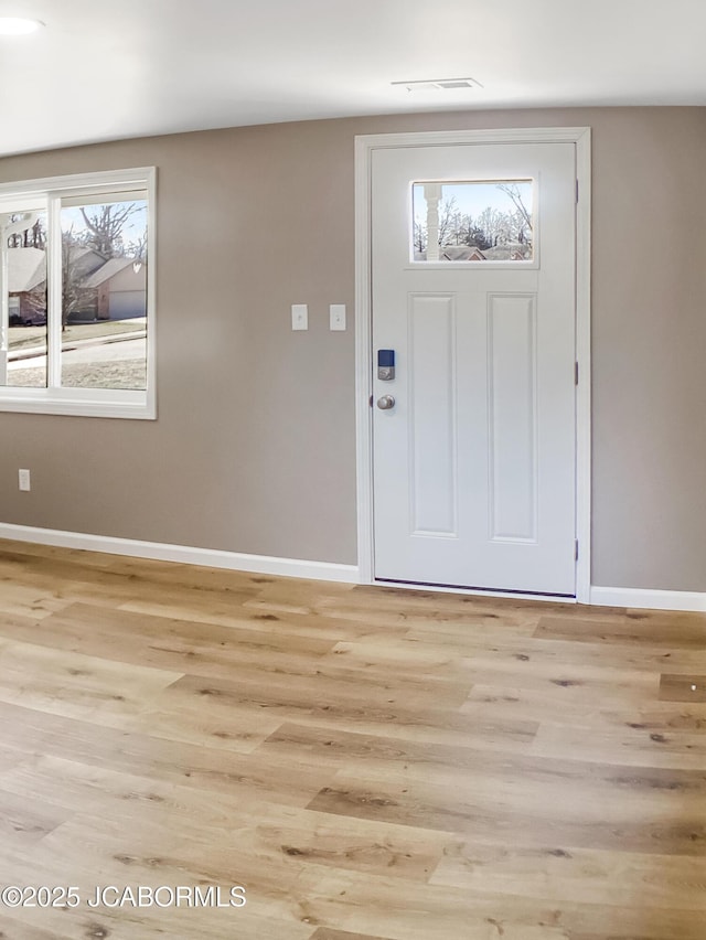 foyer featuring visible vents, light wood-style flooring, and baseboards