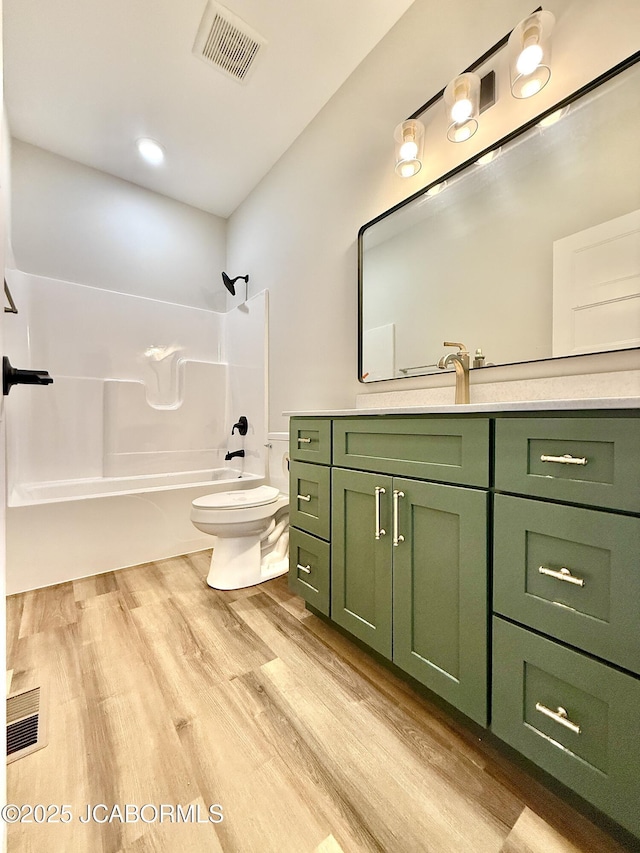 5519 Kenview Dr, Jefferson City, MO 65109 - full bathroom featuring toilet, wood finished floors, washtub / shower combination, visible vents, and vanity