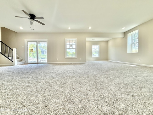 5519 Kenview Dr, Jefferson City, MO 65109 - unfurnished living room with stairs, carpet flooring, and a healthy amount of sunlight