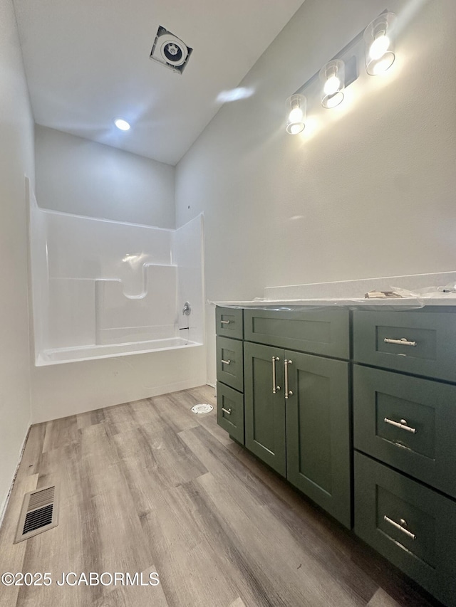 bathroom featuring a washtub, visible vents, vanity, and wood finished floors