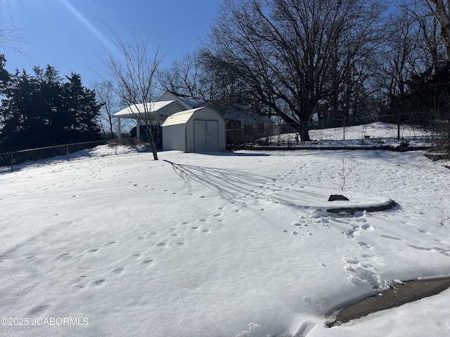 snowy yard featuring a storage shed