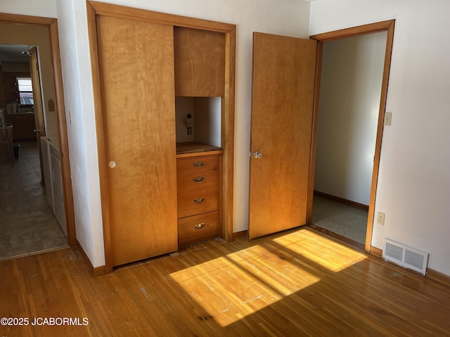 unfurnished bedroom featuring light wood-type flooring and a closet