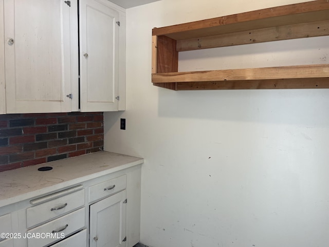 kitchen with decorative backsplash and white cabinets