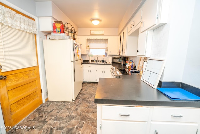 kitchen with sink, white cabinets, and black appliances