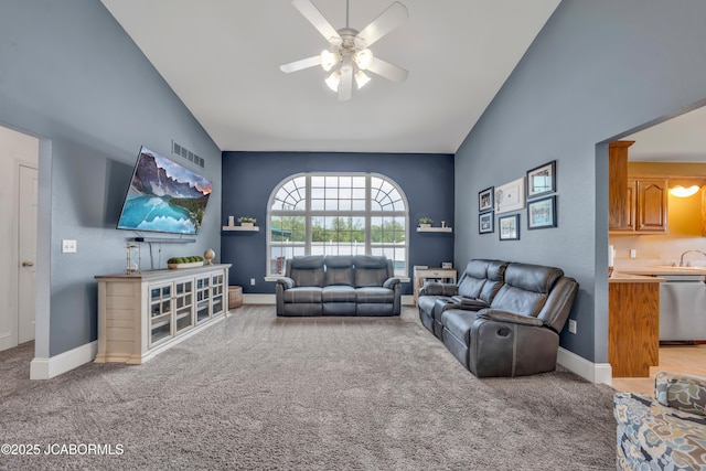living room with light colored carpet, a ceiling fan, baseboards, vaulted ceiling, and visible vents