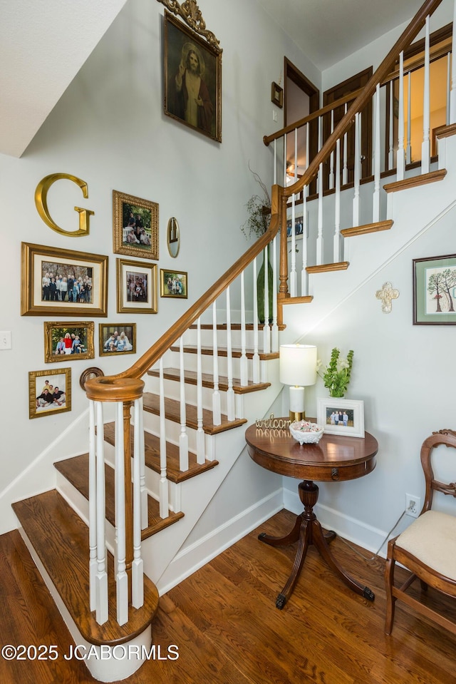 staircase with a high ceiling and hardwood / wood-style floors